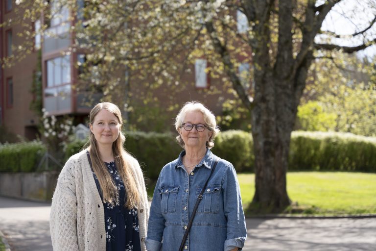 Två kvinnor utanför ett hus