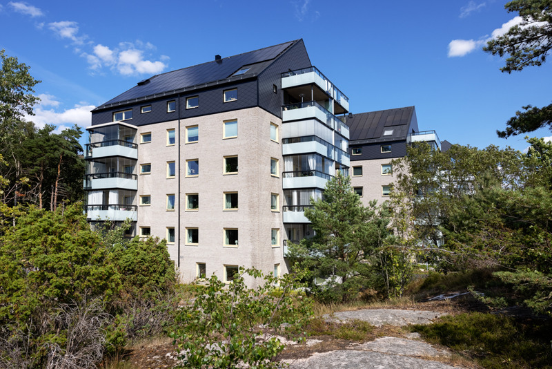 Bild på Bostadsbolagets fastigheter vid Hult Åsens Väg, i en grönskande och solig miljö. 