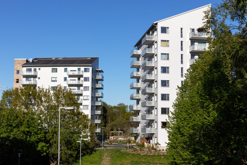Bild på Bostadsbolagets fastigheter vid Nolehultsvägen, i en solig och grönskande miljö. 