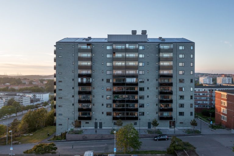 Ett hyreshus med en parkeringsplats framför sig.