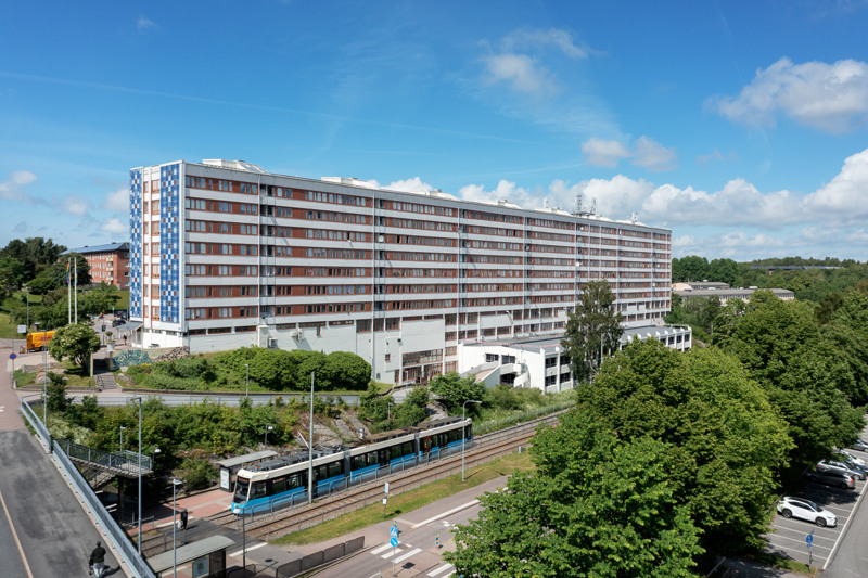 En flygbild av en byggnad med en spårvagn på spåren bredvid.