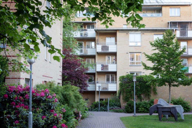 En innergård med trähästar på gräsmattan.