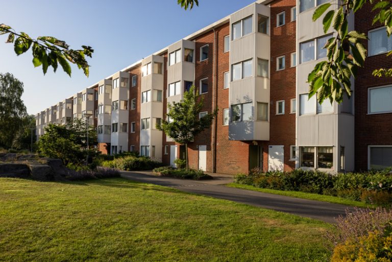 En rad hyreshus i tegel en solig dag.