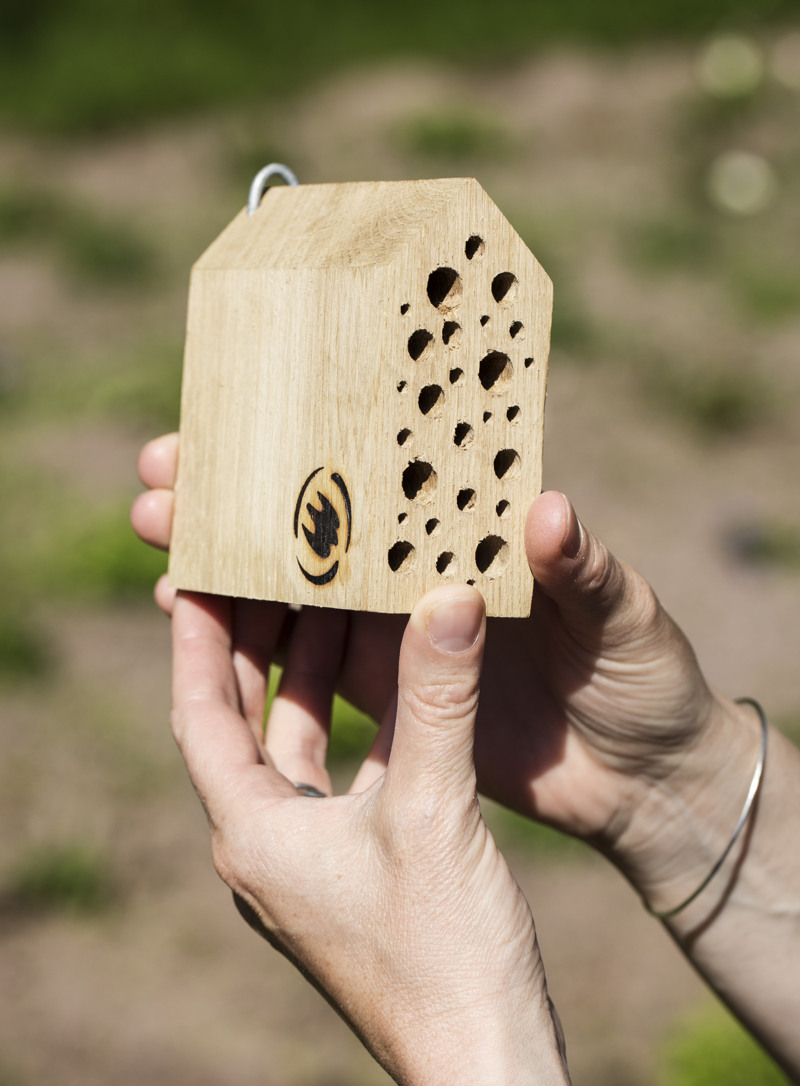 En person som håller i ett träföremål med hål i.