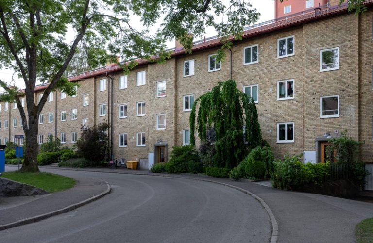 En krökt väg framför en tegelbyggnad.