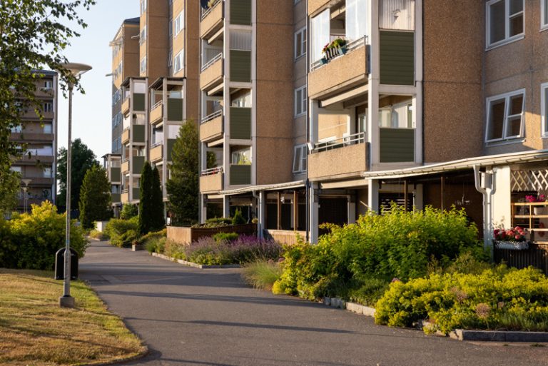 En rad flerfamiljshus på en gata i en stad.