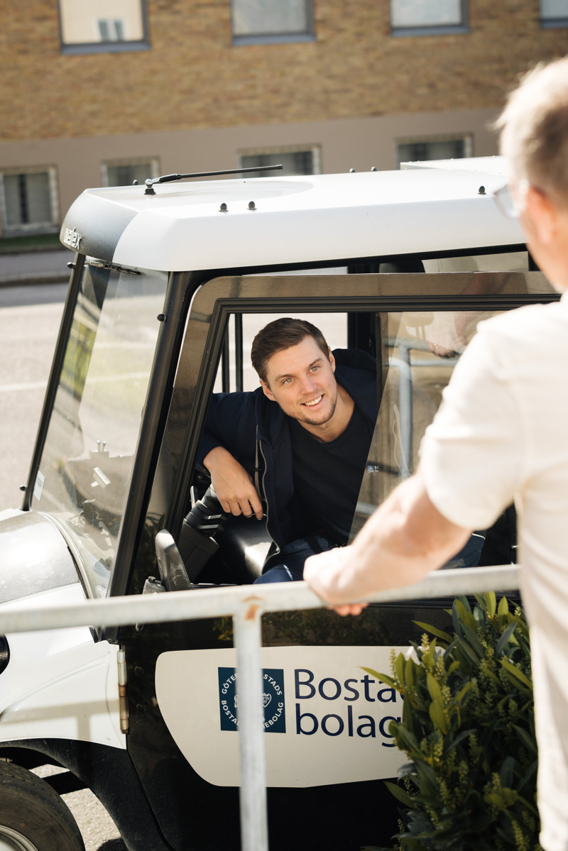 En man som står bredvid en vit golfbil.