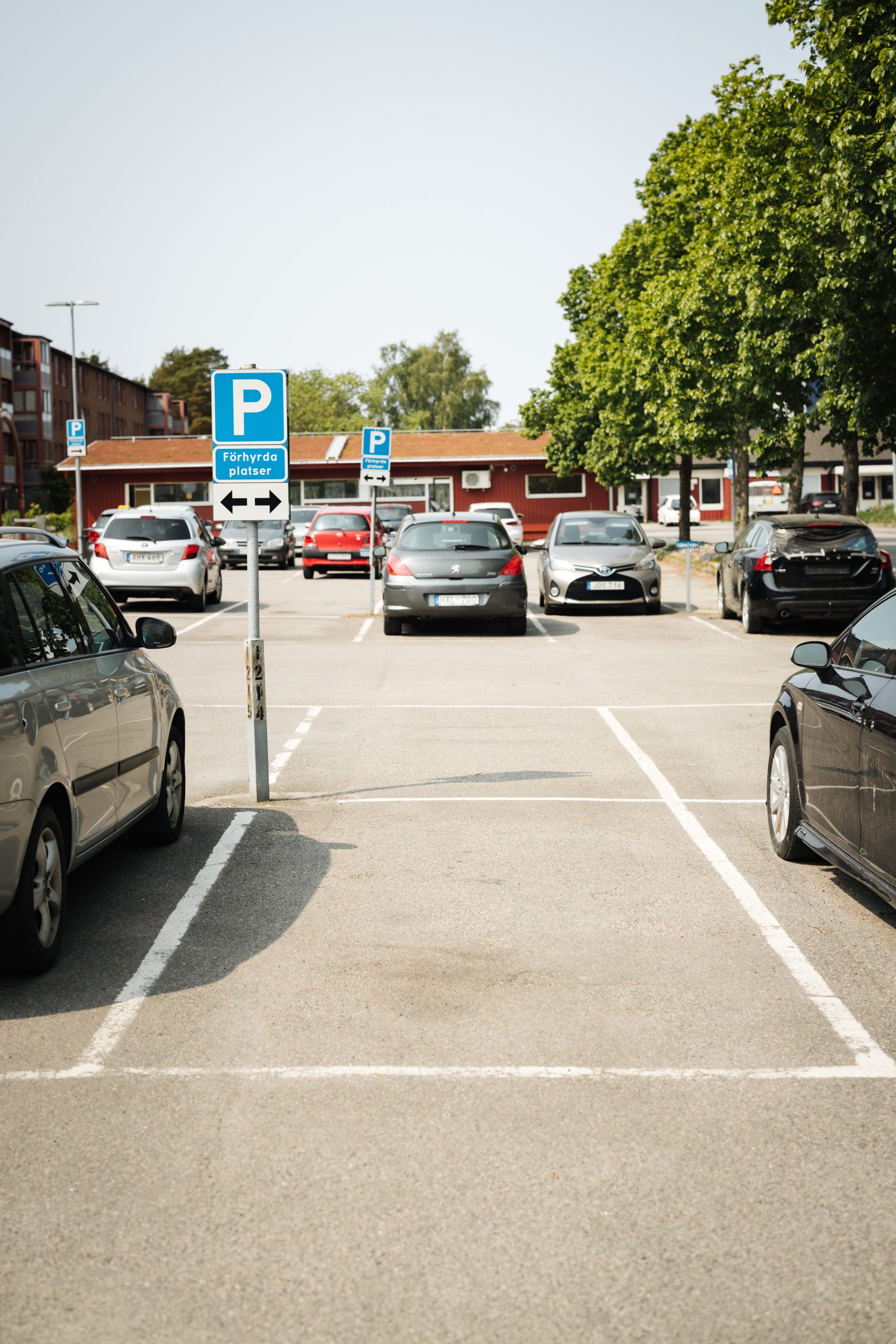 En parkeringsplats fylld med massor av parkerade bilar.