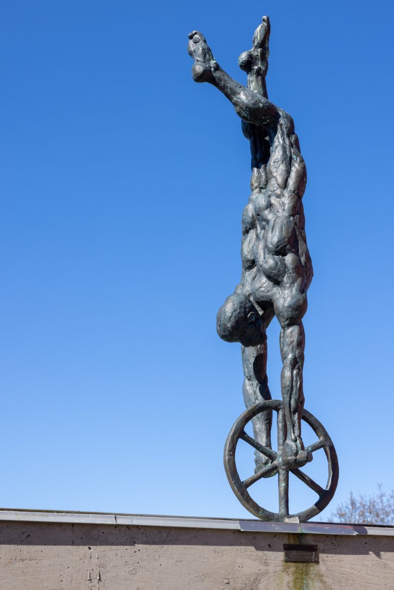 En staty av en man som åker på ett hjul.