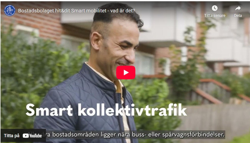 En stillbild från Bostadsbolagets video om smart mobilitet, som visar en man som står framför ett lägenhetshus och ler. 