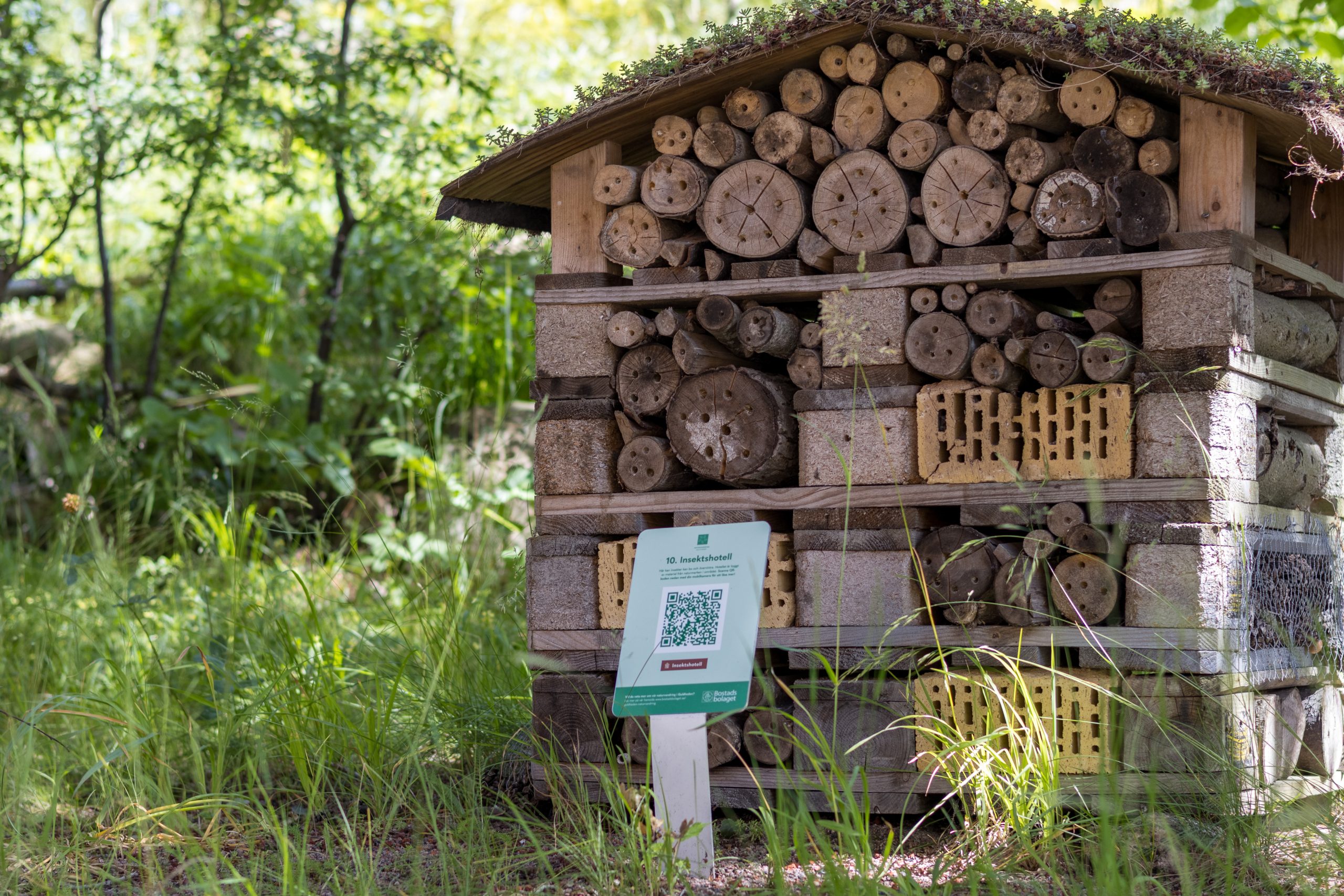 Ett litet hus av trä med en skylt framför.