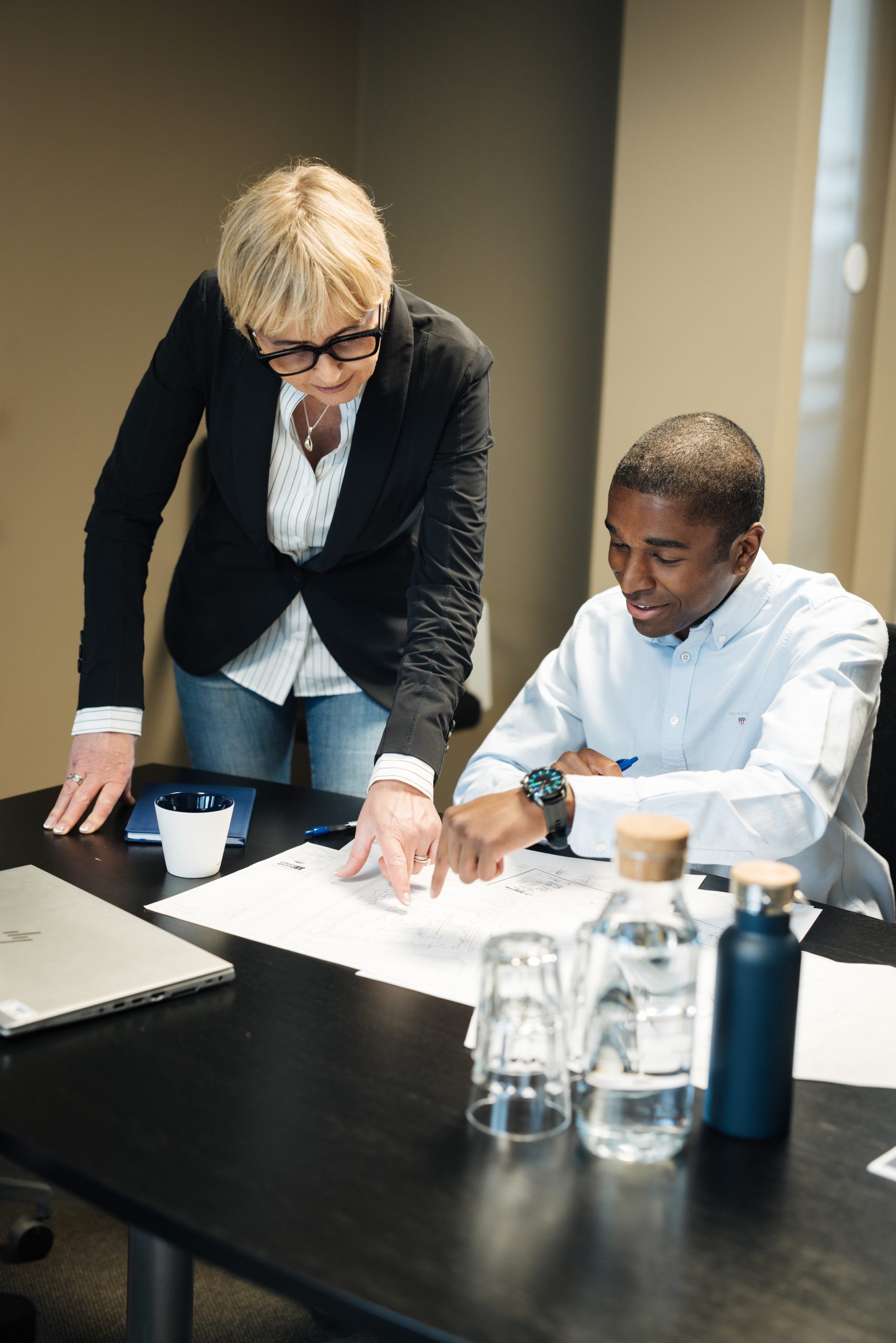 En man och en kvinna sitter vid ett bord och tittar på ett par papper som ligger framför dem.