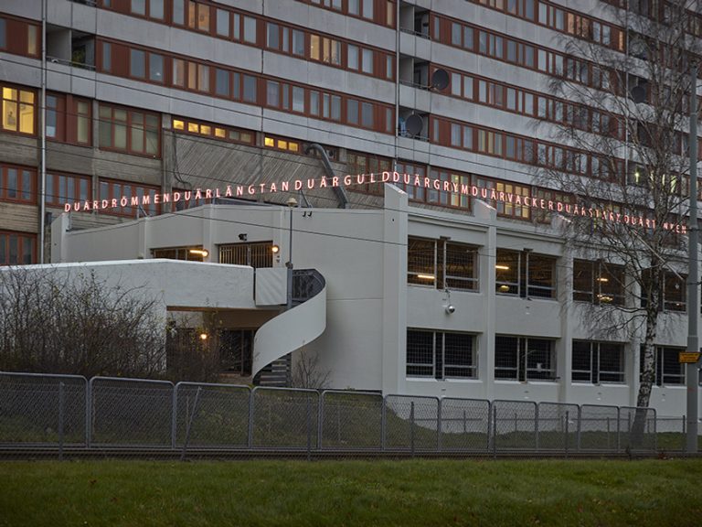 En stor byggnad med en skylt där det står "Du är drömmen, du är längtan, du är guld".