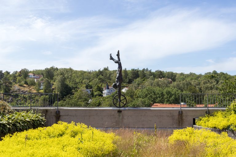 En staty av en person som står på händerna på ett hjul-