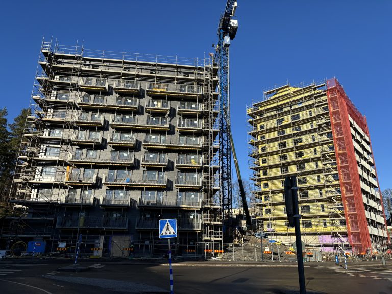 En hög byggnad med en lyftkran på toppen.