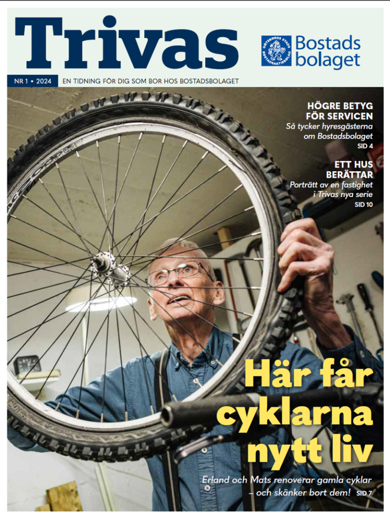 En man håller ett cykelhjul framför sitt ansikte.