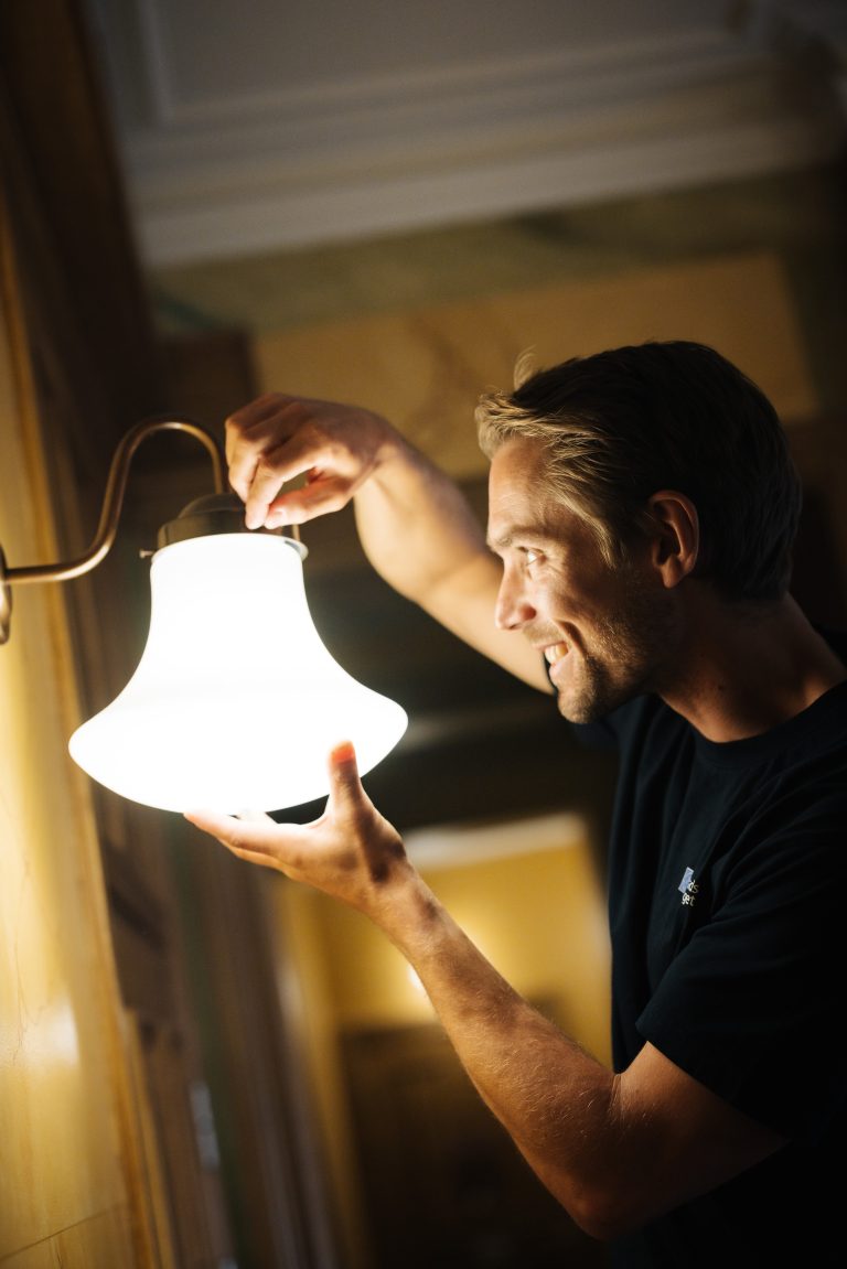 En man som håller en lampa i sin hand.