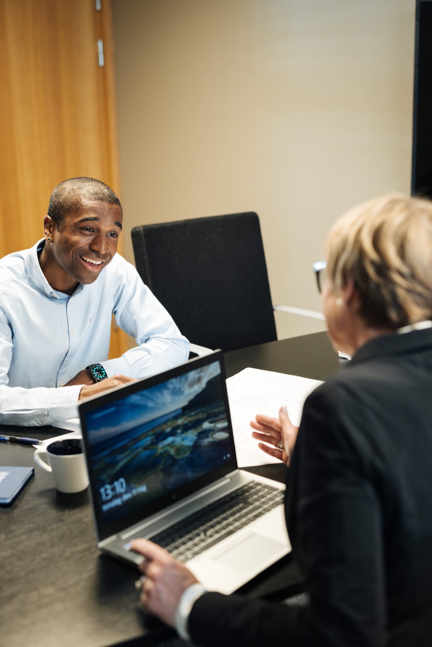En kvinna och en man sitter tillsammans vid ett bord och tittar på en dator. 