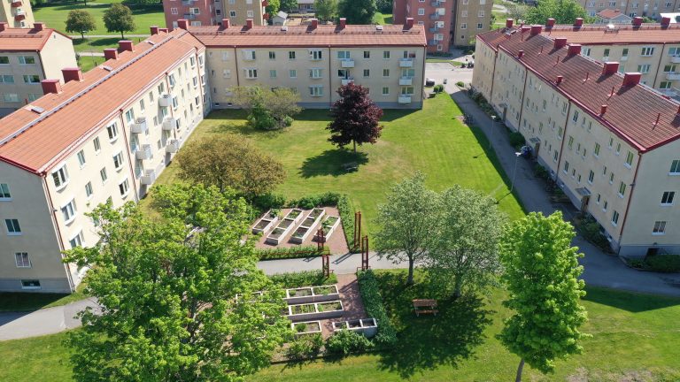 En flygbild av en byggnad med en trädgård framför sig.