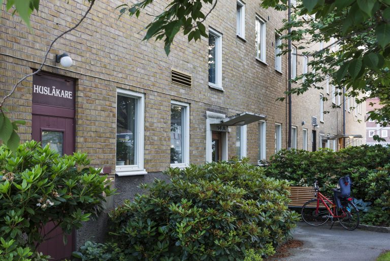 En cykel parkerad framför en tegelbyggnad.