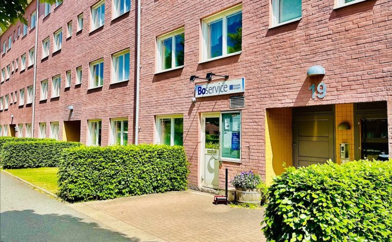 En röd tegelbyggnad med en skylt på framsidan.