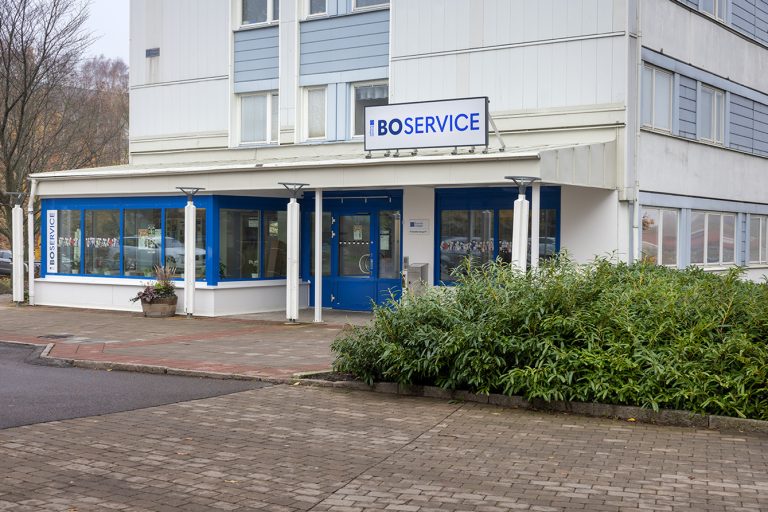 En blå och vit byggnad som ligger intill en gata.