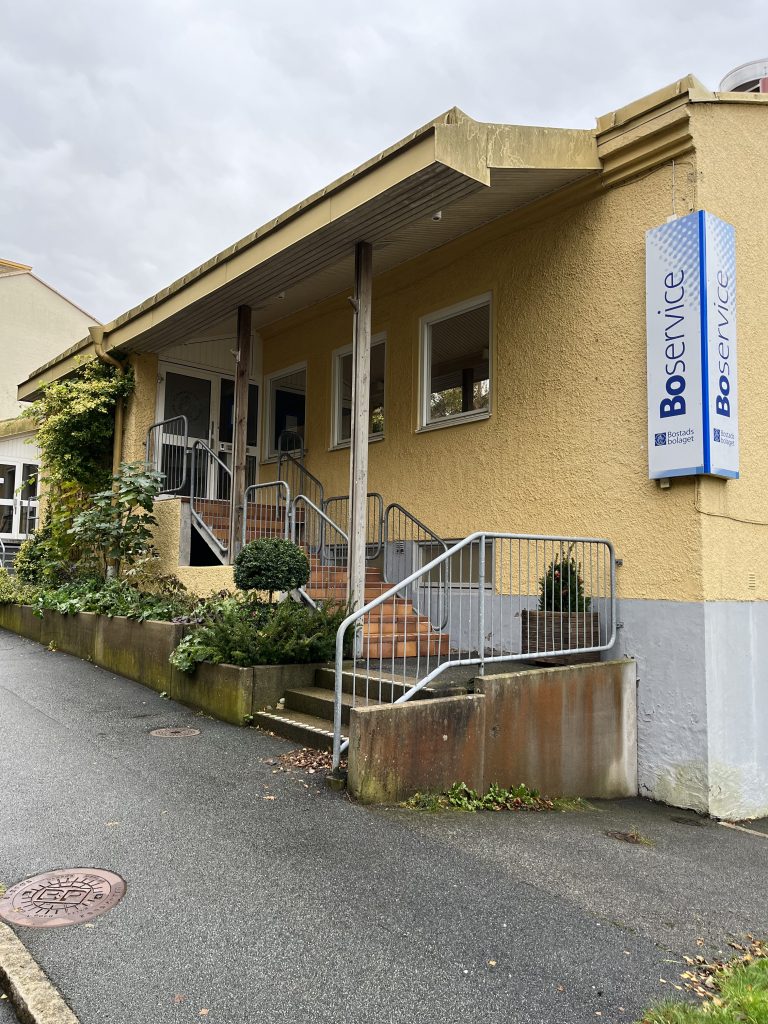 En gul byggnad med en blå skylt på framsidan.