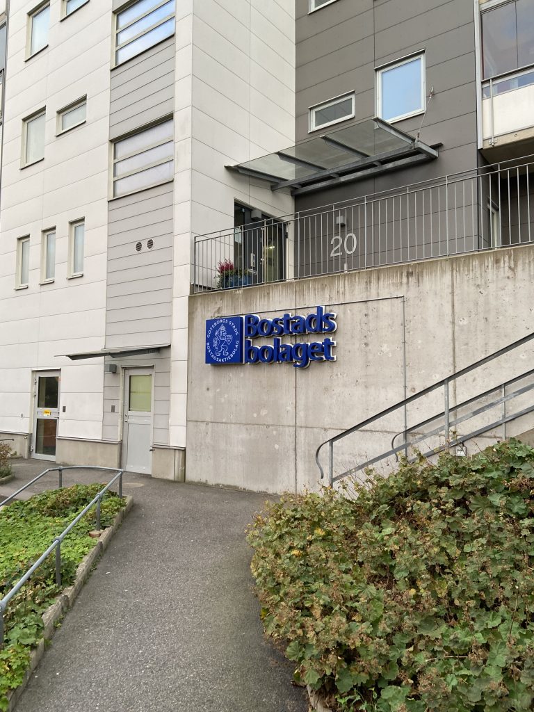 Ingången till en byggnad med en blå skylt på.