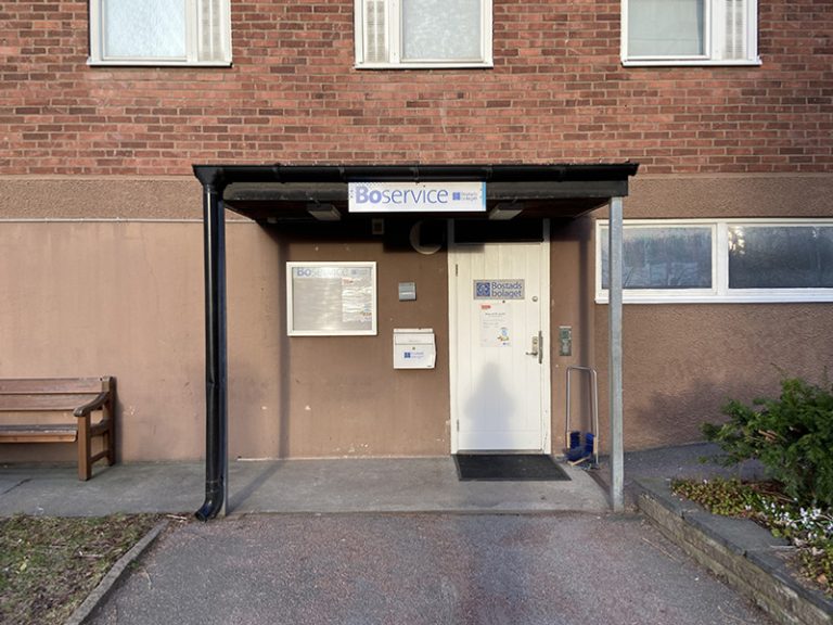 En byggnad med en dörr och en bänk framför.