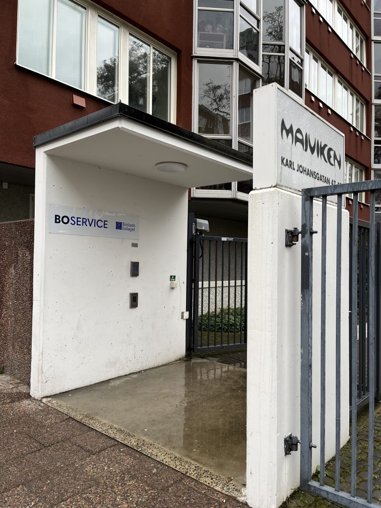 Ingången till en byggnad med ett staket runt.