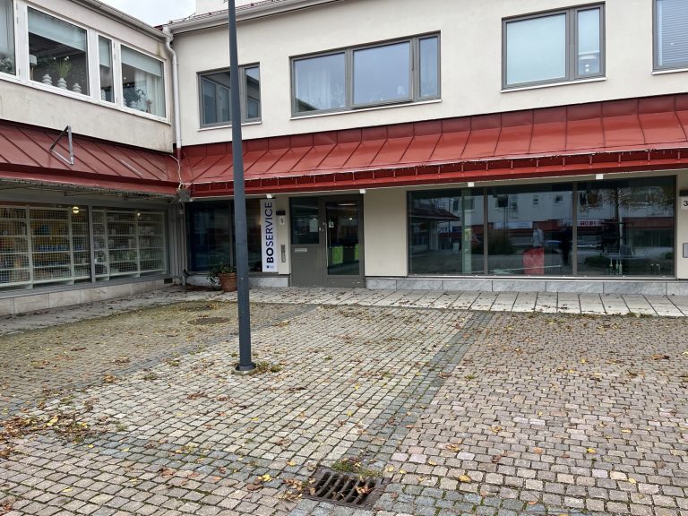 En byggnad med en röd markis intill en gata.