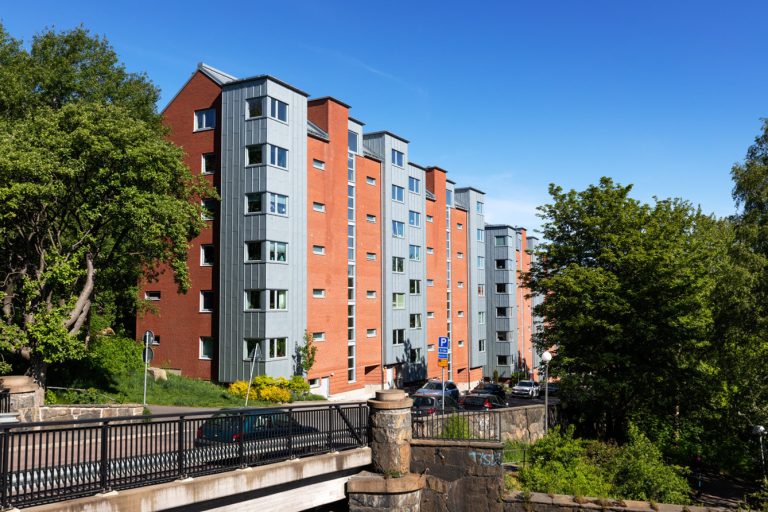 En bro som går över en väg bredvid en hög byggnad.