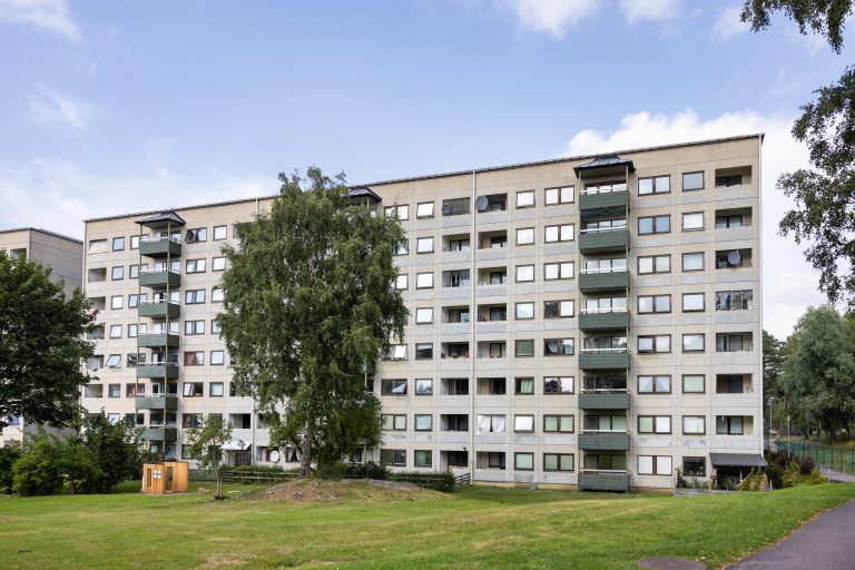 Ett flerbostadshus med balkonger och balkonger på andra våningen.