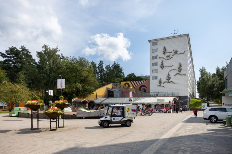 En liten bil som står parkerad framför en byggnad.