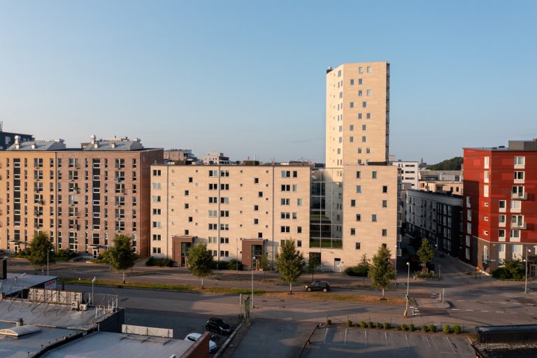 En stad med många höga byggnader bredvid en parkeringsplats.