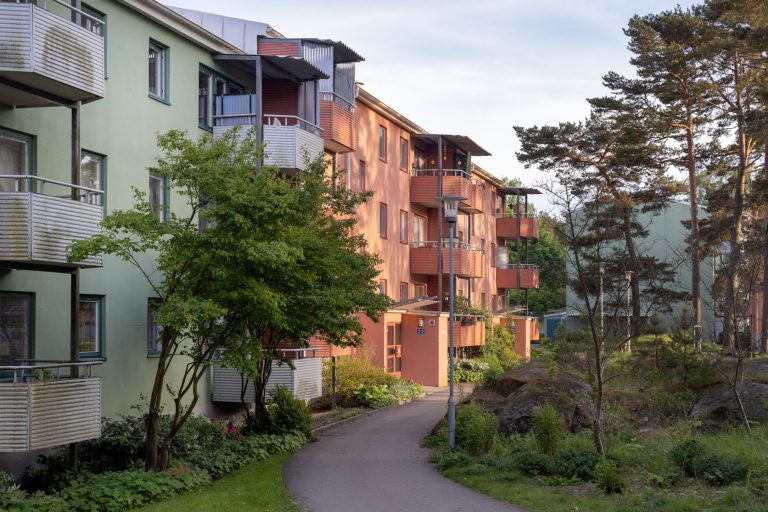 En gångväg framför en rad flerfamiljshus.