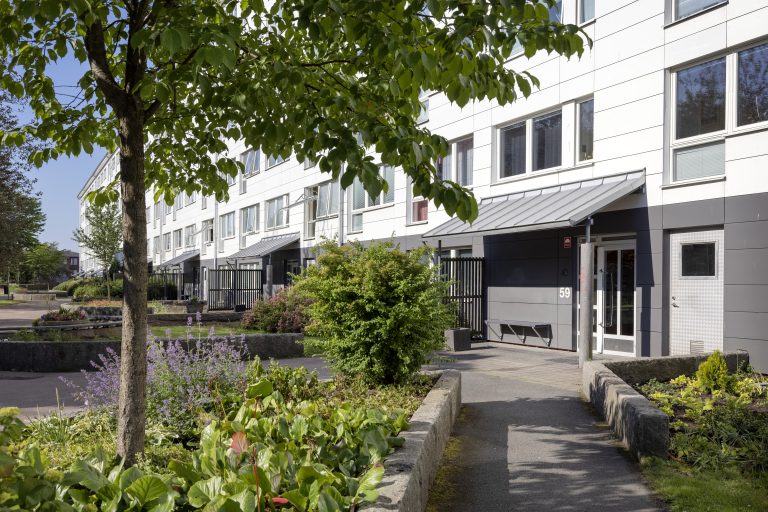 En byggnad med en gångväg som leder till ytterdörren.