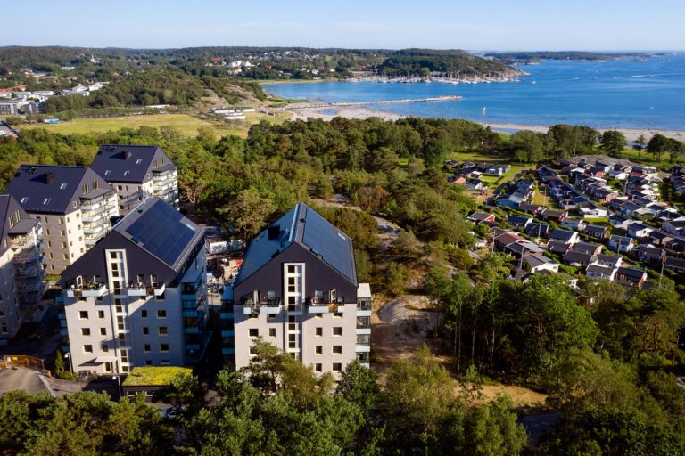 Ett fågelperspektiv av hus med havet i bakgrunden.