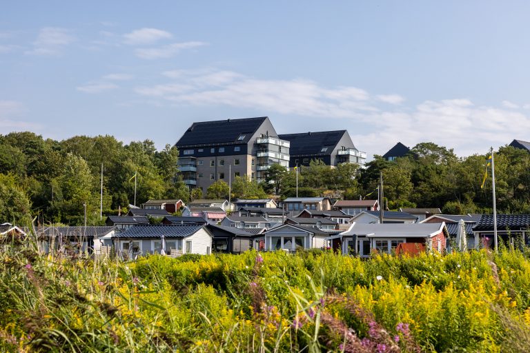 En rad hus som ligger på toppen av en grönskande sluttning.