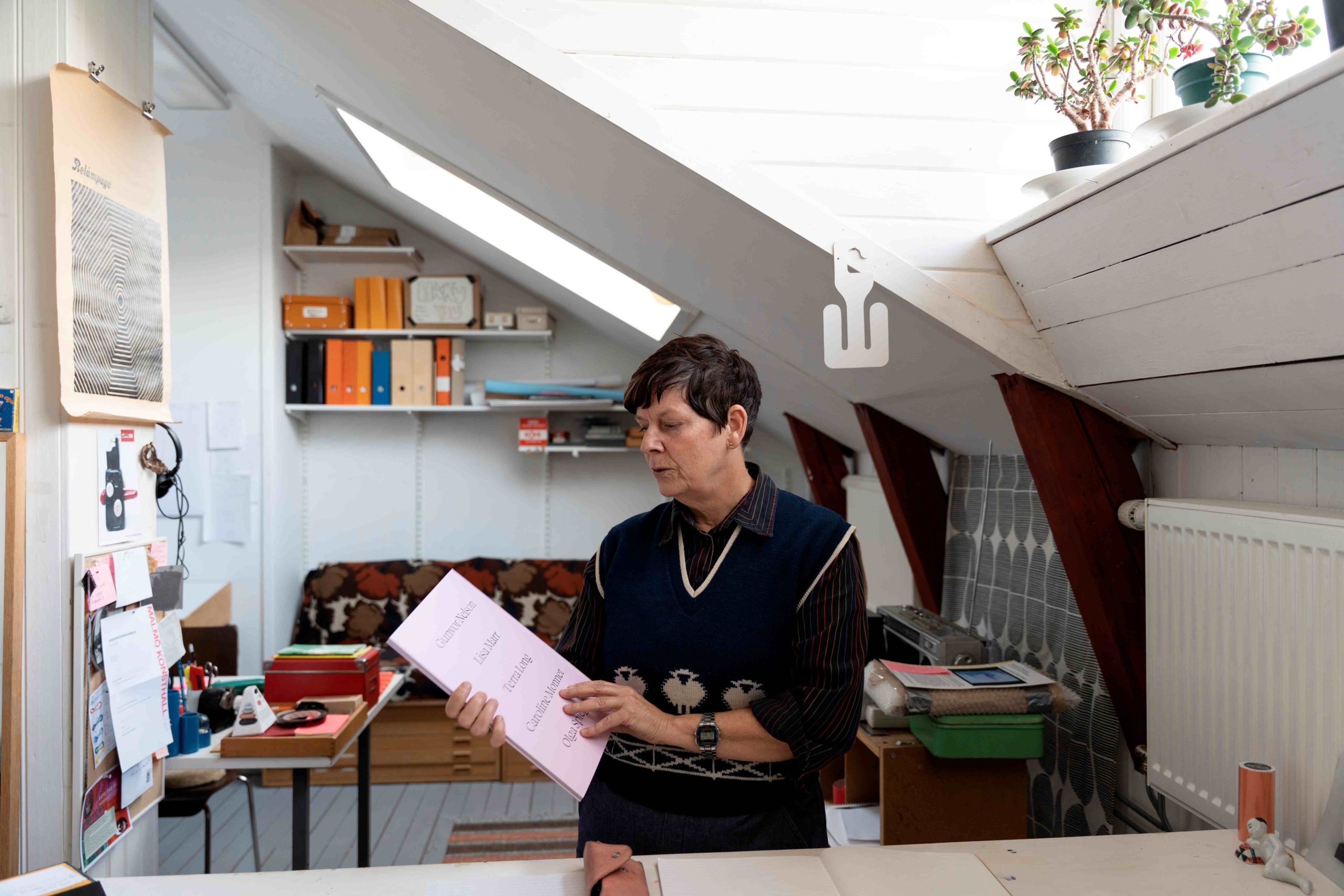 En kvinna tittar på en bok hon håller i handen.