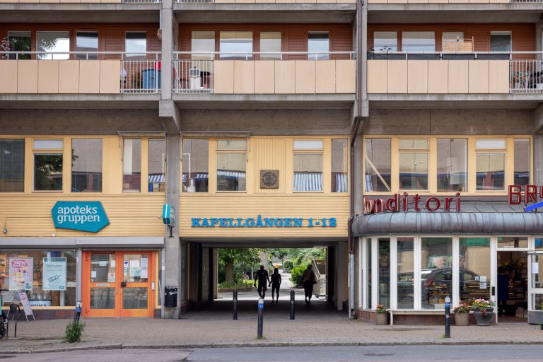 En lägenhetsbyggnad med människor som går framför den.