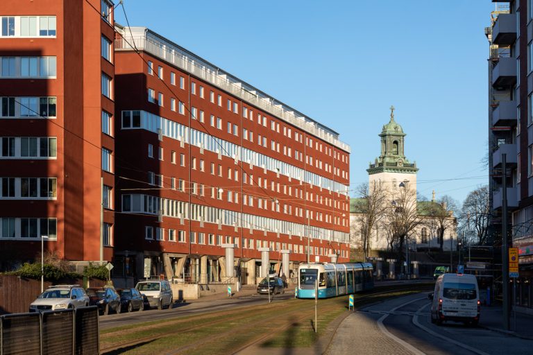 En stadsgata kantad av höga röda tegelbyggnader.
