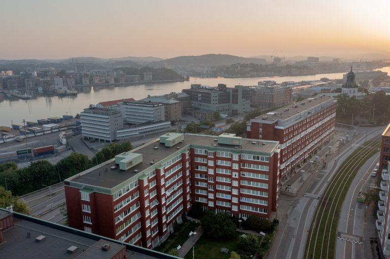 En flygbild av en stad med havet i bakgrunden.