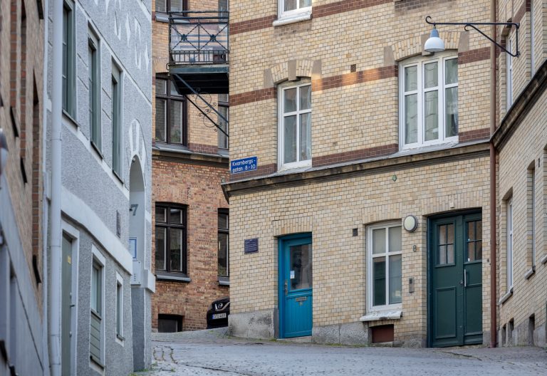 Flera tegelbyggnader mitt emot varandra i en uppförsbacke.