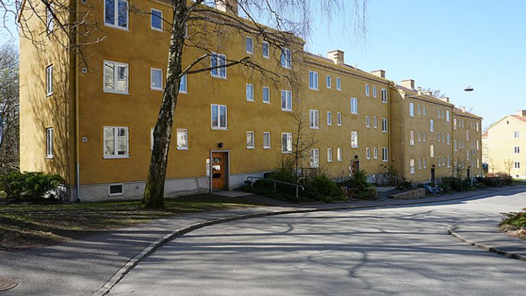 En gata med en gul byggnad och en brandpost.