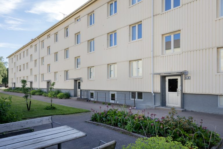 En byggnad med en träbänk framför.