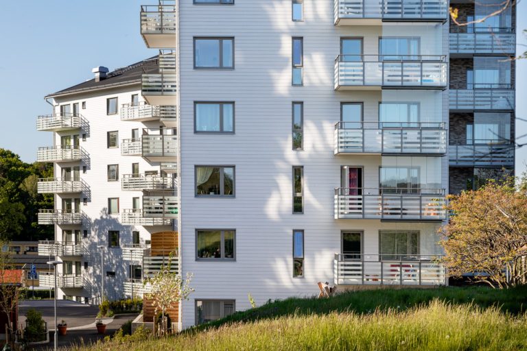 En hög vit byggnad med balkonger och balkonger.