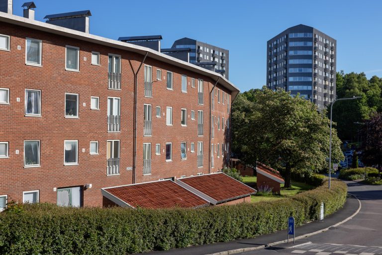 En röd tegelbyggnad med många fönster på sidan av den.