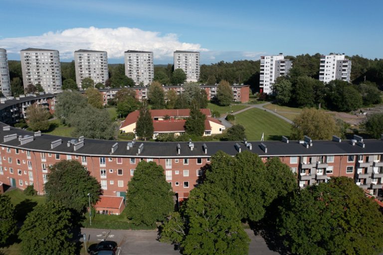 En flygbild av en stor tegelbyggnad omgiven av träd.