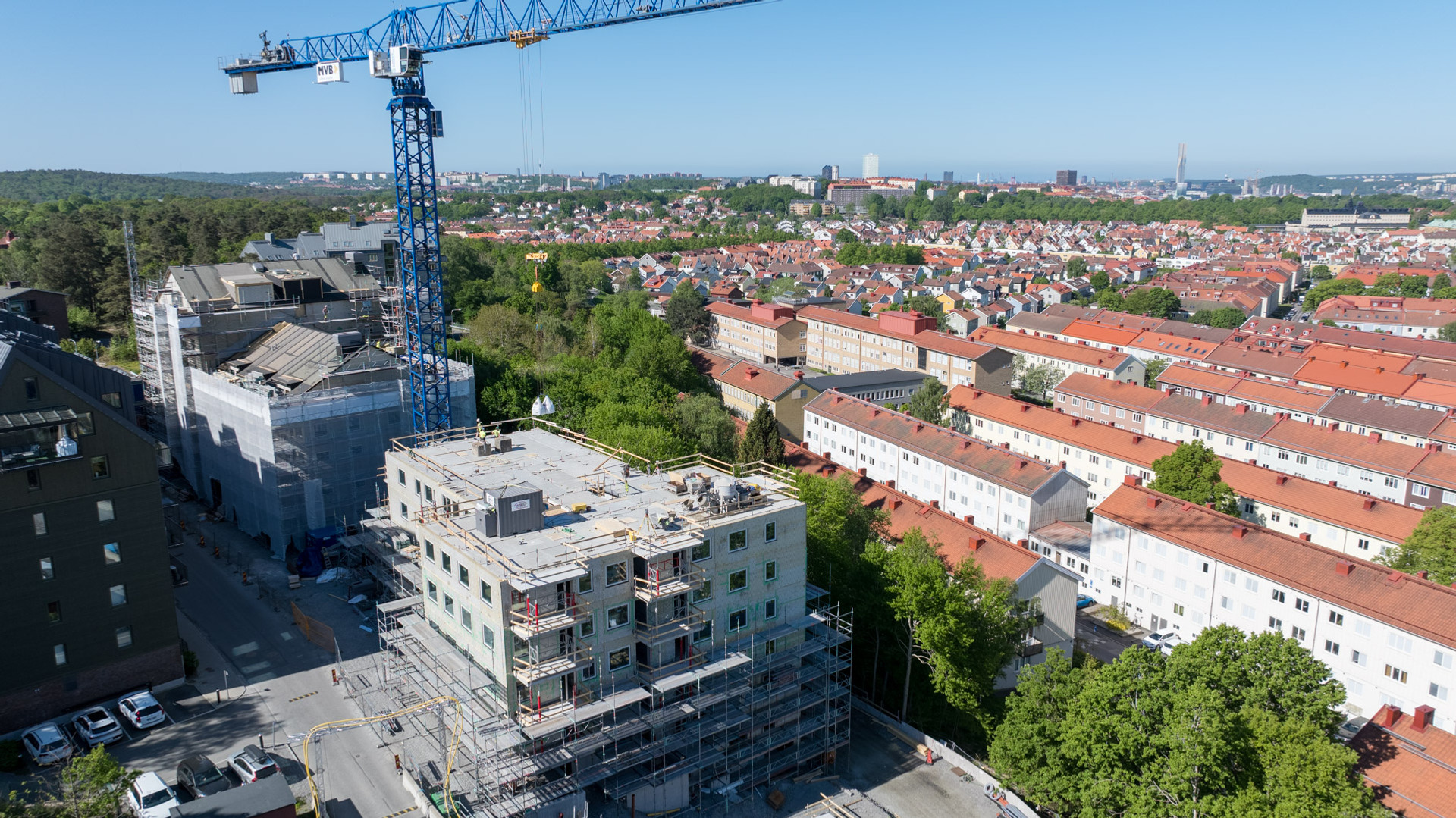En kran som står på toppen av en byggnad. Bygge av bostäder. 